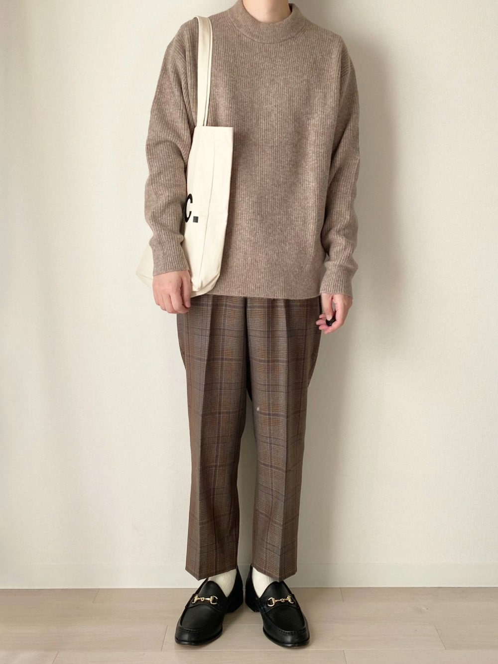 ベージュ系のニット/セーター、ブラウン系のその他パンツ、ブラック系のローファーを着用したメンズの秋コーディネートの1枚目の写真