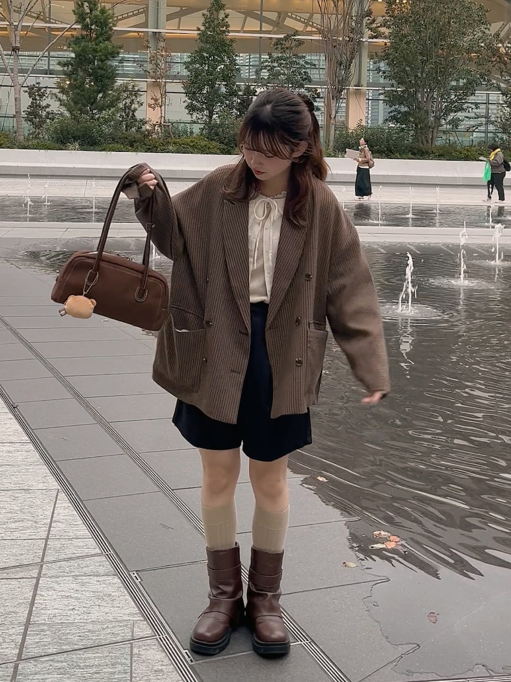 ブラック系のその他パンツ、その他のテーラードジャケット、ブラウン系のハンドバッグを着用したレディースの秋コーディネートの1枚目の写真