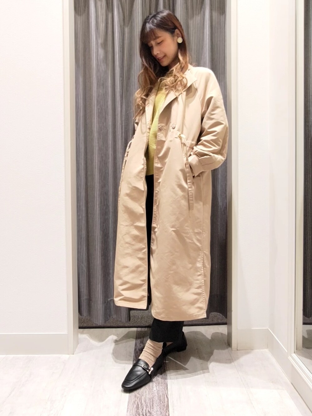 ベージュ系のその他アウター、イエロー系のニット/セーター、ブラック系のドレスシューズを着用したレディースの秋コーディネートの1枚目の写真