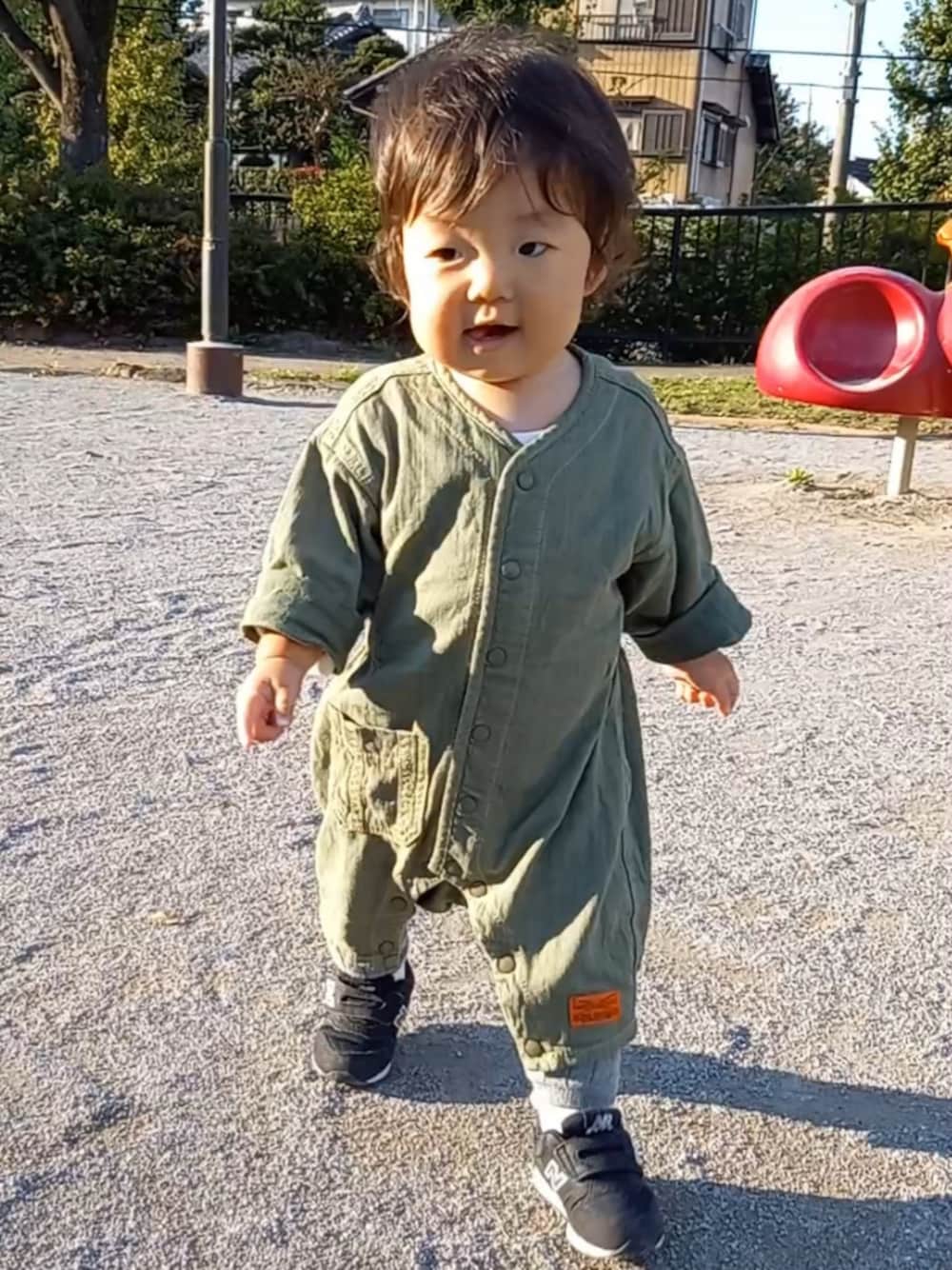 ブラック系のスニーカー、グリーン系のロンパースを着用したキッズの秋コーディネートの1枚目の写真