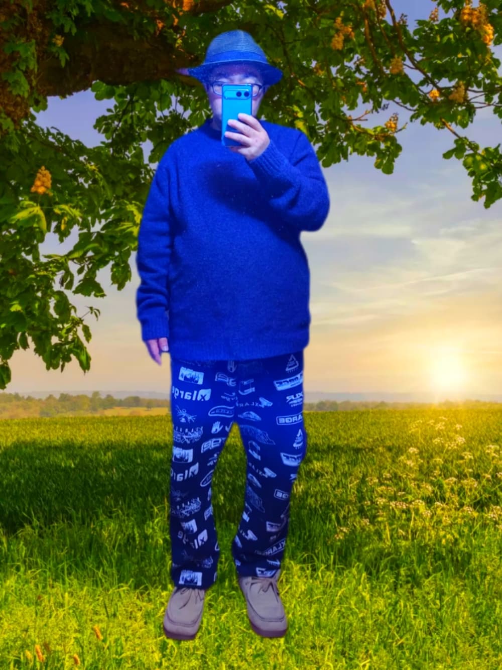 パープル系のニット/セーター、ブラック系のスウェットパンツ、ベージュ系のモカシン/デッキシューズを着用したメンズの春コーディネートの1枚目の写真