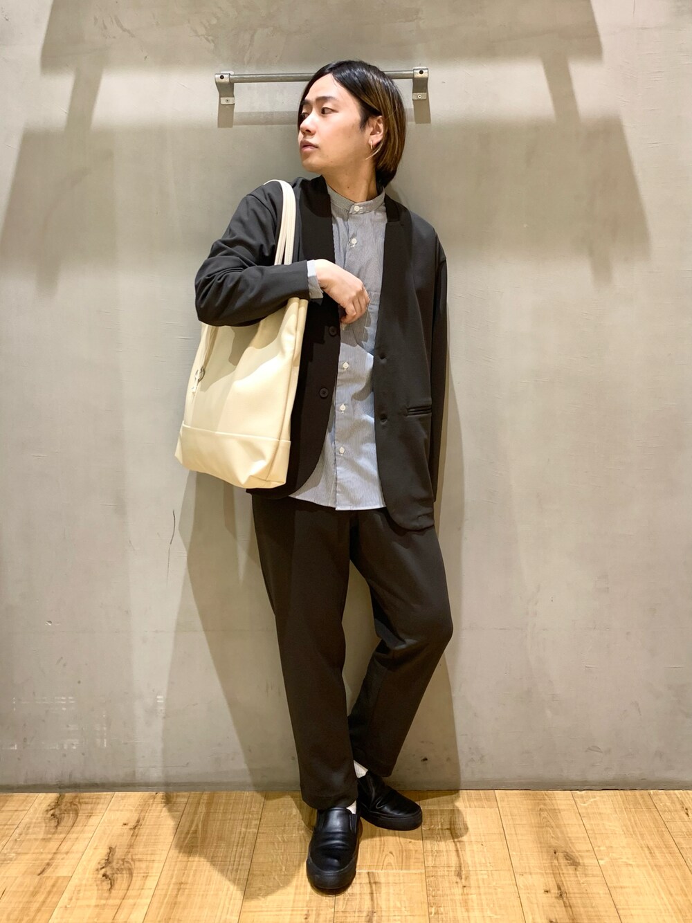 グレー系のノーカラージャケット、グレー系のトートバッグ、その他のスニーカーを着用したメンズの冬コーディネートの1枚目の写真