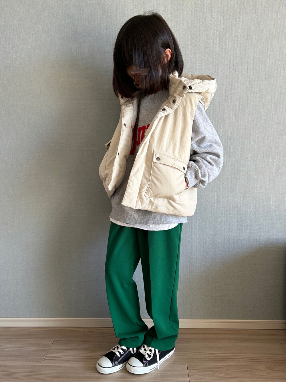 ホワイト系のダウンベスト、グレー系のスウェット、ホワイト系のTシャツ/カットソーを着用したキッズの冬コーディネートの1枚目の写真
