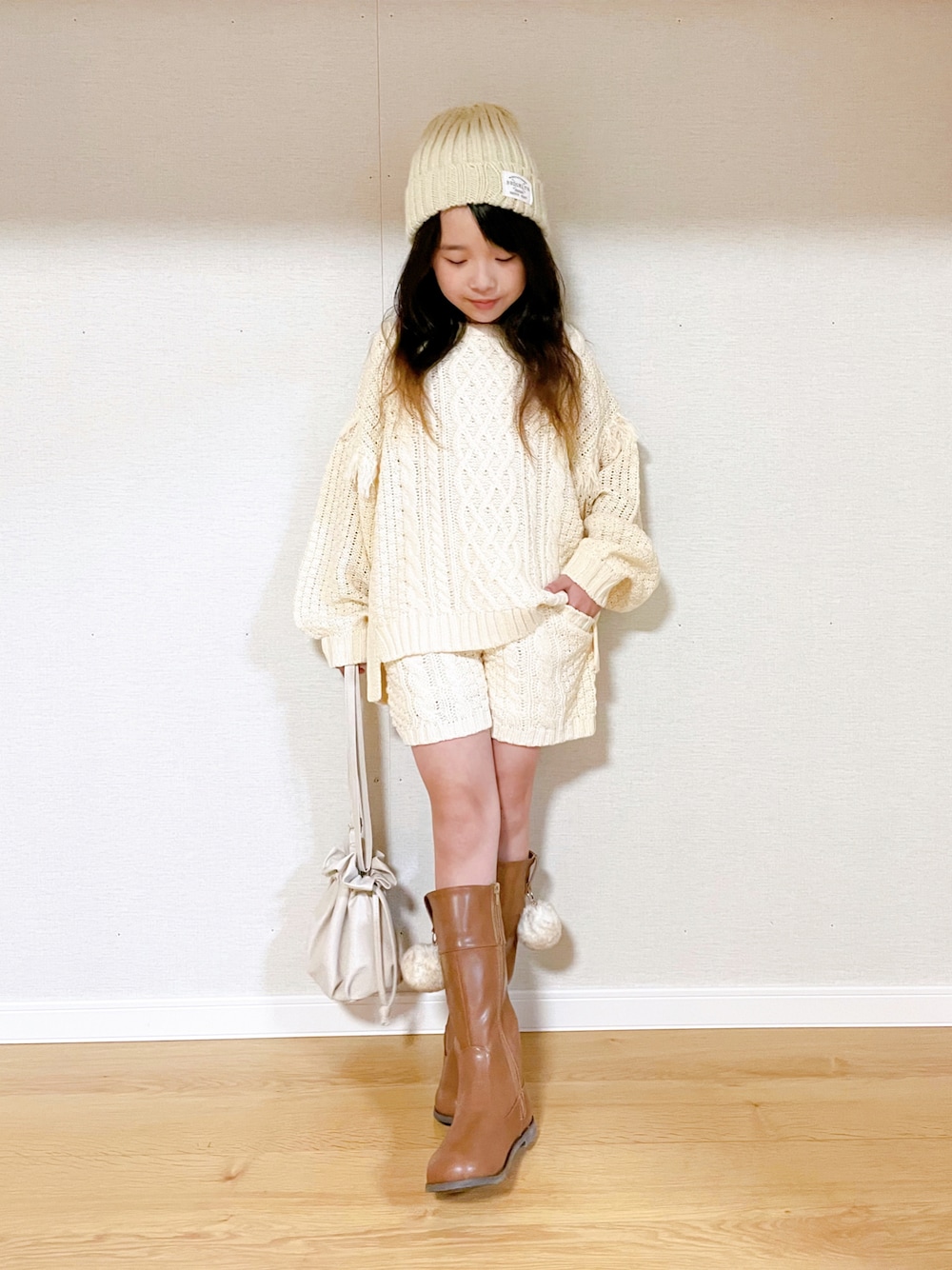 「セットアップ、ブーツ、レザー、ニット帽、ショートパンツ、ケーブルニット、冬コーデ、ロングブーツ、白ニット、キッズコーデ、巾着バッグ、白パンツ、ホワイトコーデ、シンプルコーデ、小学生」｜「BREEZEのケーブルフリンジニット（ニット/セーター、ホワイト系）」を使った、naaaさん（キッズ・130cm）の冬コーディネートの1枚目の写真