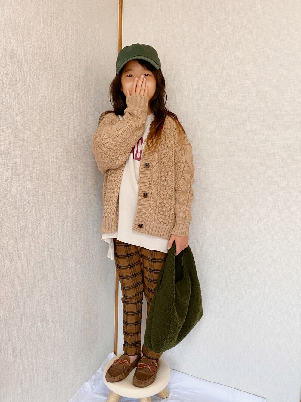 ベージュ系のカーディガン/ボレロ、ホワイト系のスウェット、ブラウン系のチノパンツを着用したキッズの秋コーディネートの1枚目の写真