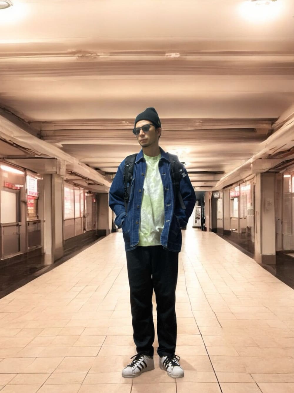 ブラック系のチノパンツ、グリーン系のスウェット、ホワイト系のスニーカーを着用したメンズの秋コーディネートの1枚目の写真