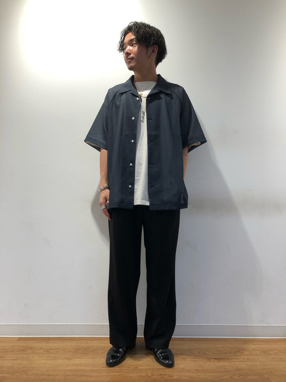 ブルー系のシャツ/ブラウス、ブラック系のスラックス、ブラック系のシューズを着用したメンズの春コーディネートの1枚目の写真