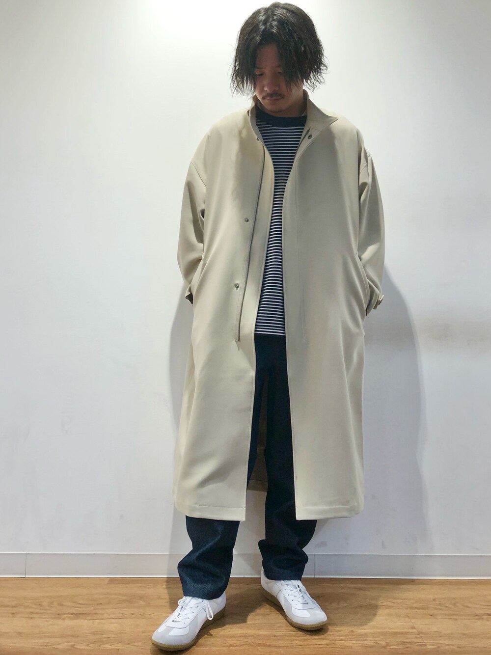 ブルー系のニット/セーター、ベージュ系のモッズコート、ブルー系のデニムパンツを着用したメンズの春コーディネートの1枚目の写真