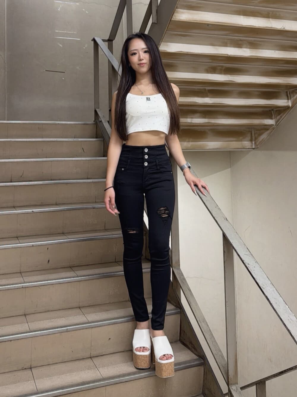 ホワイト系のサンダル、ホワイト系のキャミソール、ブラック系のデニムパンツを着用したレディースの夏コーディネートの1枚目の写真