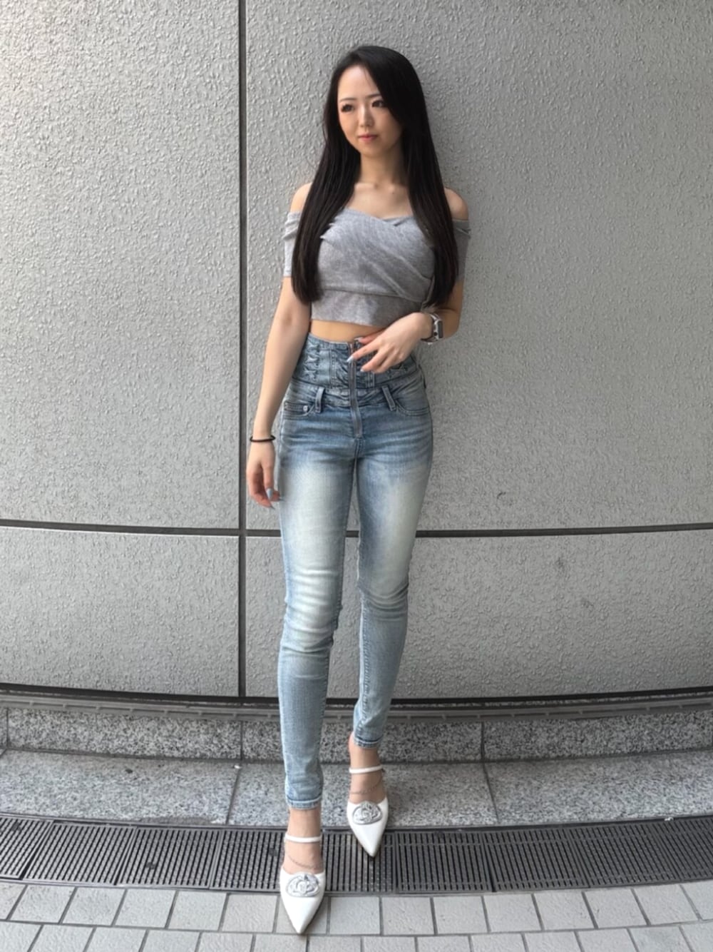 グレー系のTシャツ/カットソー、ブルー系のデニムパンツ、ホワイト系のパンプスを着用したレディースの春コーディネートの1枚目の写真