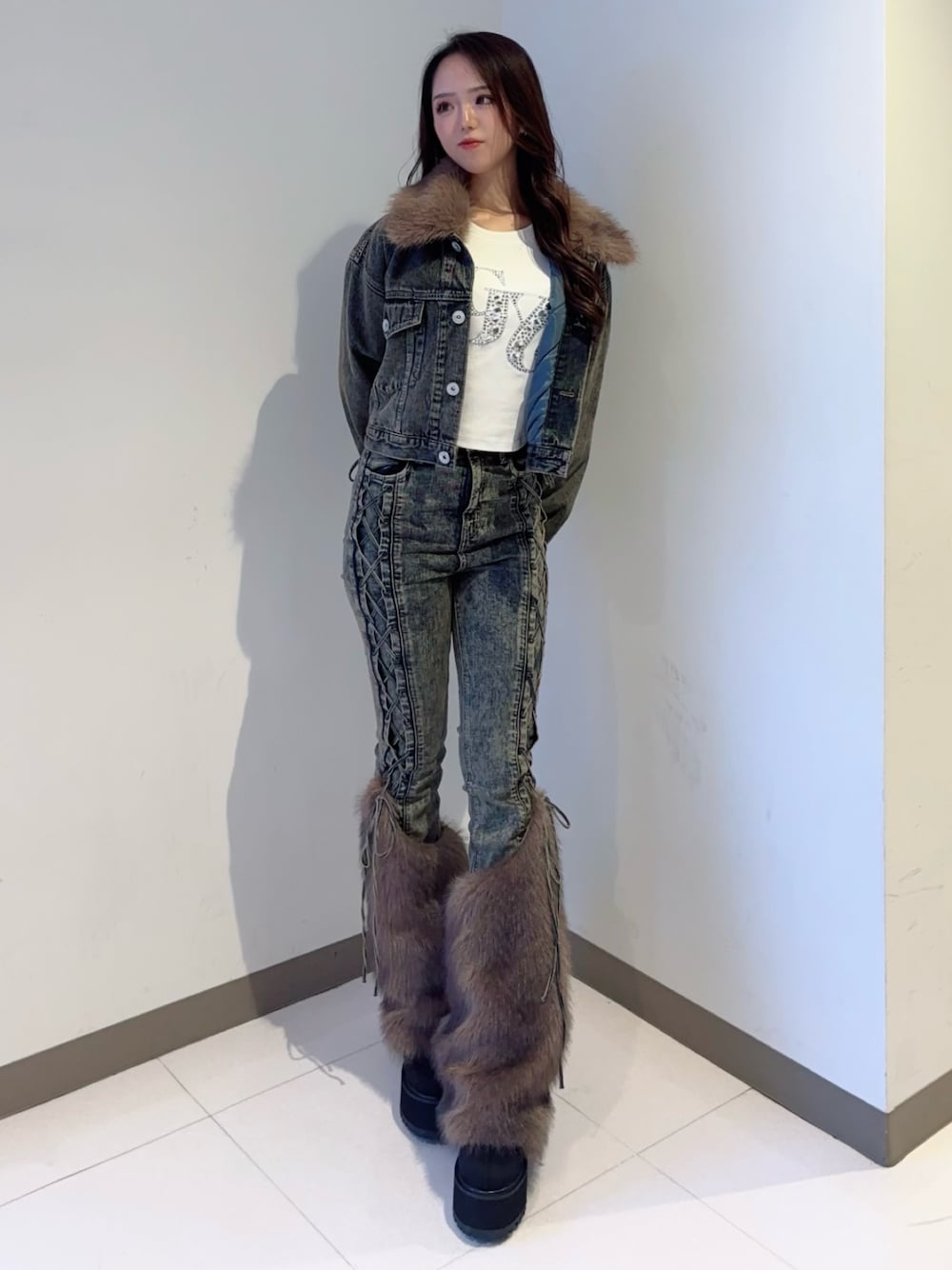 ブルー系のデニムジャケット、ブルー系のデニムパンツ、ブラック系のブーツを着用したレディースの秋コーディネートの1枚目の写真