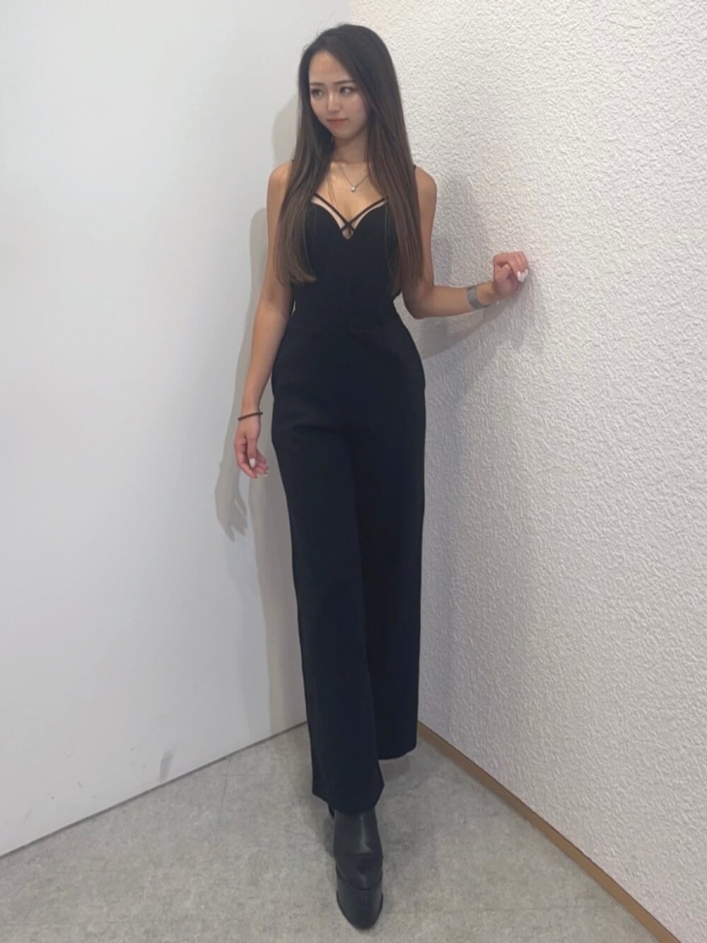 ブラック系のつなぎ/オールインワン、ブラック系のブーツ、ブラック系のブラジャーを着用したレディースの秋コーディネートの1枚目の写真