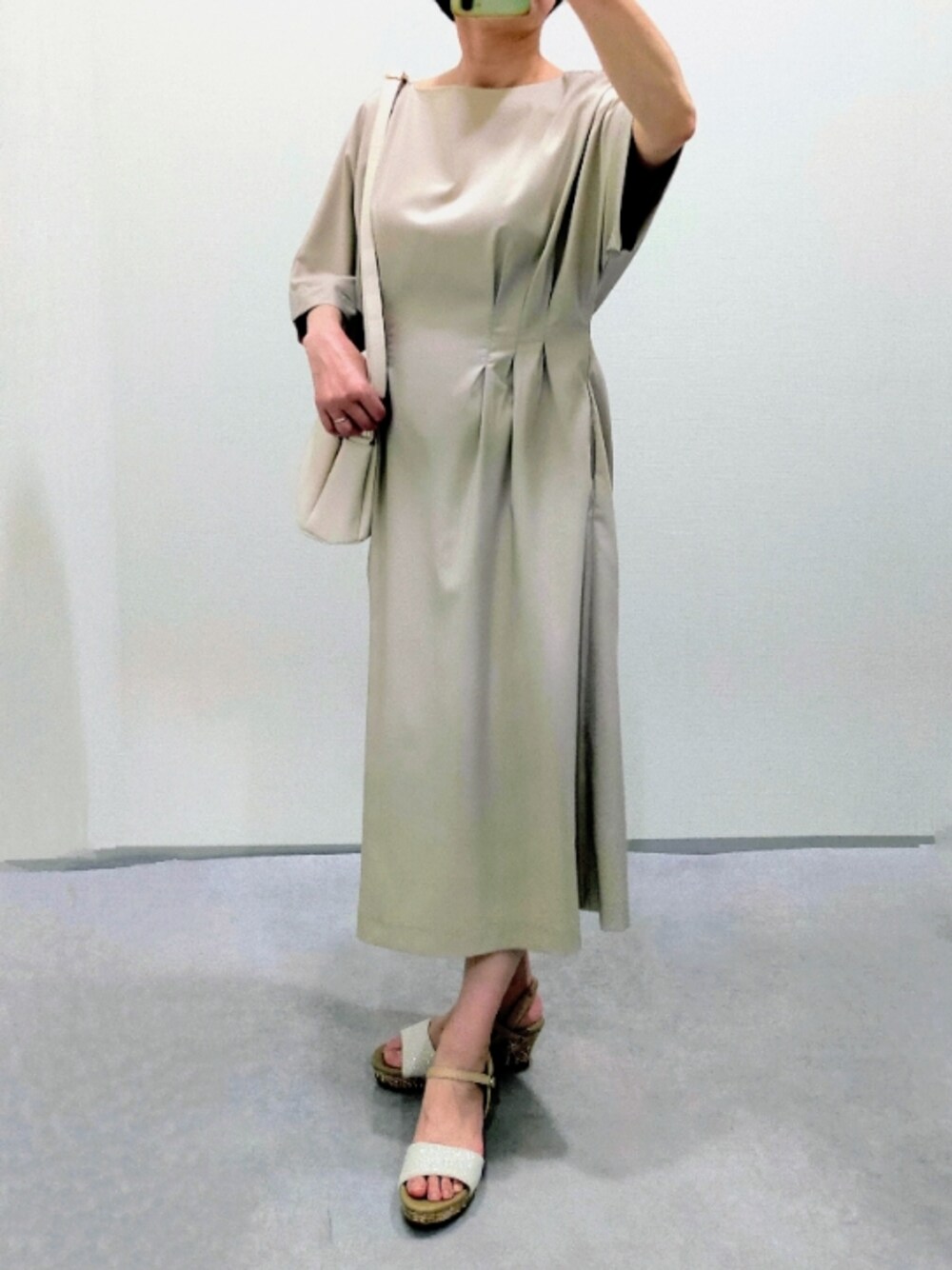 ホワイト系のショルダーバッグ、ベージュ系のワンピース、ベージュ系のサンダルを着用したレディースの夏コーディネートの1枚目の写真