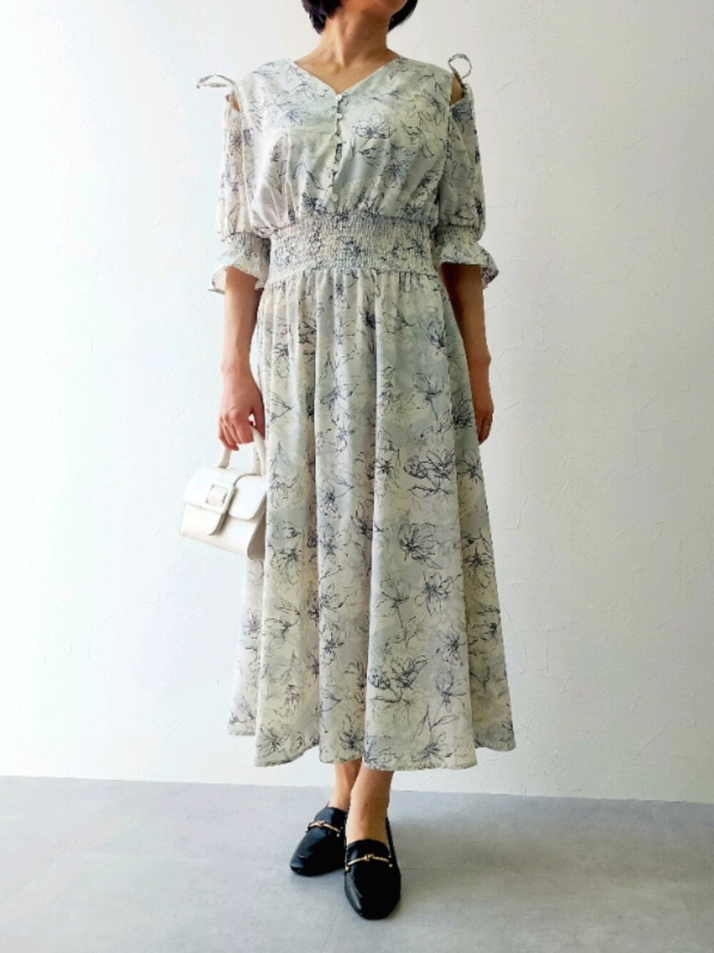 ブラック系のローファー、ホワイト系のワンピースを着用したレディースの春コーディネートの1枚目の写真