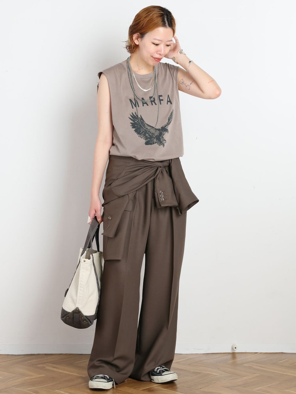 グリーン系のテーラードジャケット、グリーン系のスラックス、ベージュ系のTシャツ/カットソーを着用したレディースの夏コーディネートの1枚目の写真