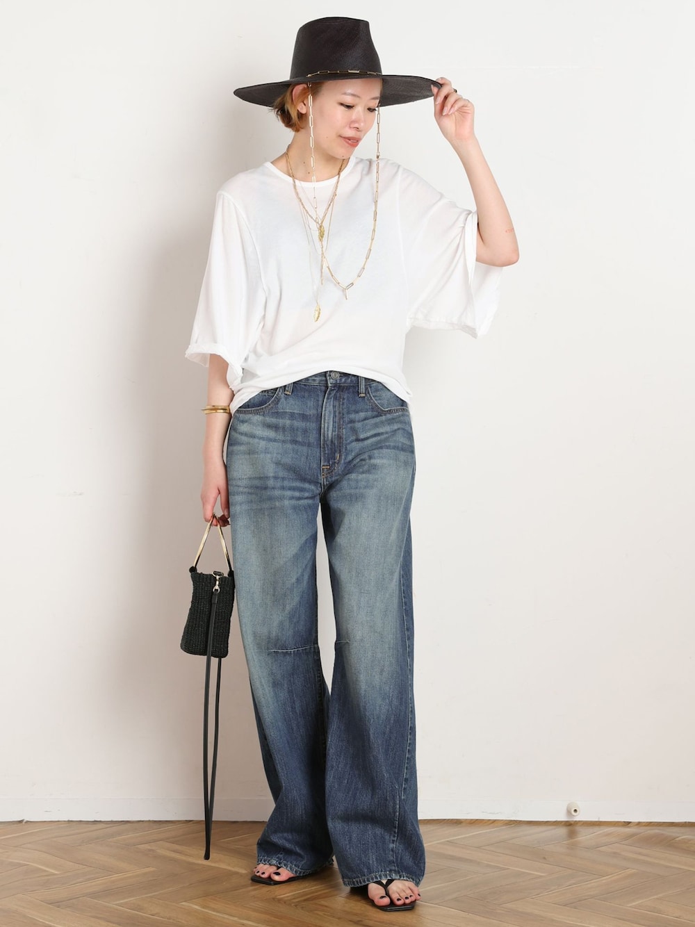 ホワイト系のTシャツ/カットソー、ブラック系のショルダーバッグ、ブラック系のサンダルを着用したレディースの夏コーディネートの1枚目の写真