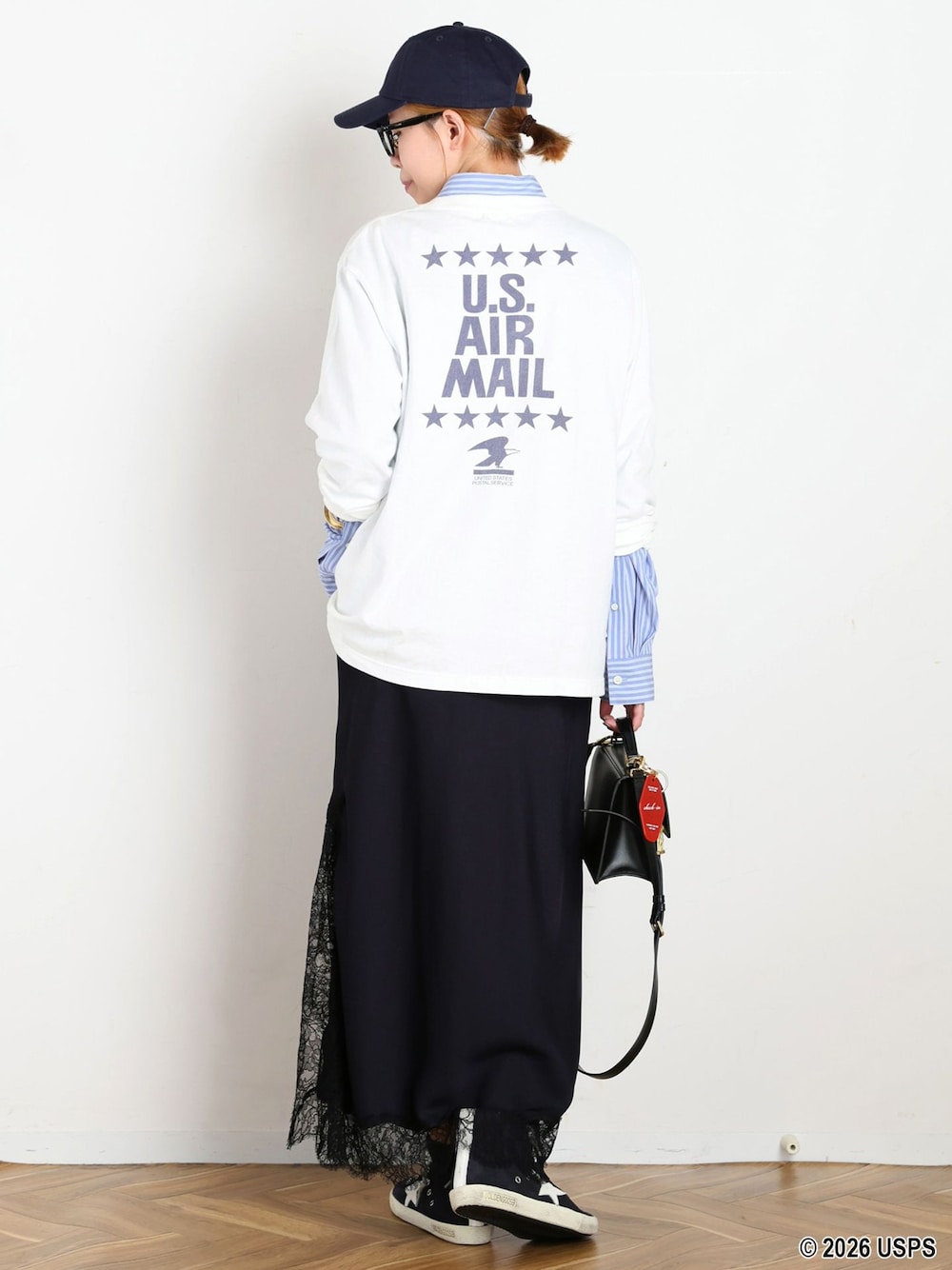 ホワイト系のTシャツ/カットソー、ブルー系のキャップを着用したレディースの夏コーディネートの1枚目の写真