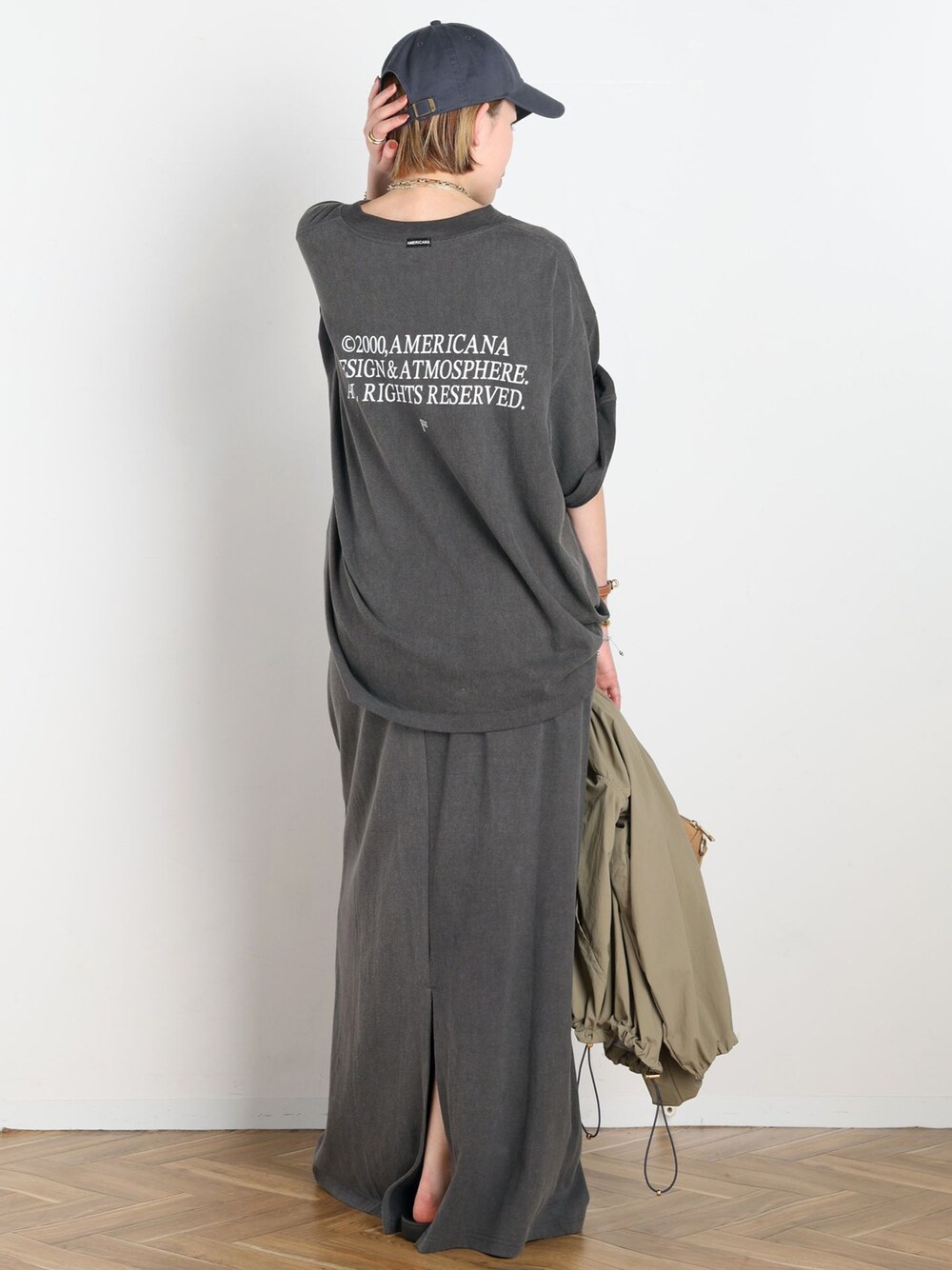 ベージュ系のナイロンジャケット、ブラック系のスカート、ブラック系のTシャツ/カットソーを着用したレディースの春コーディネートの1枚目の写真