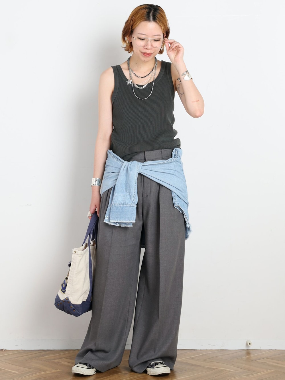 グレー系のスラックス、ブルー系のシャツ/ブラウス、グレー系のタンクトップを着用したレディースの夏コーディネートの1枚目の写真