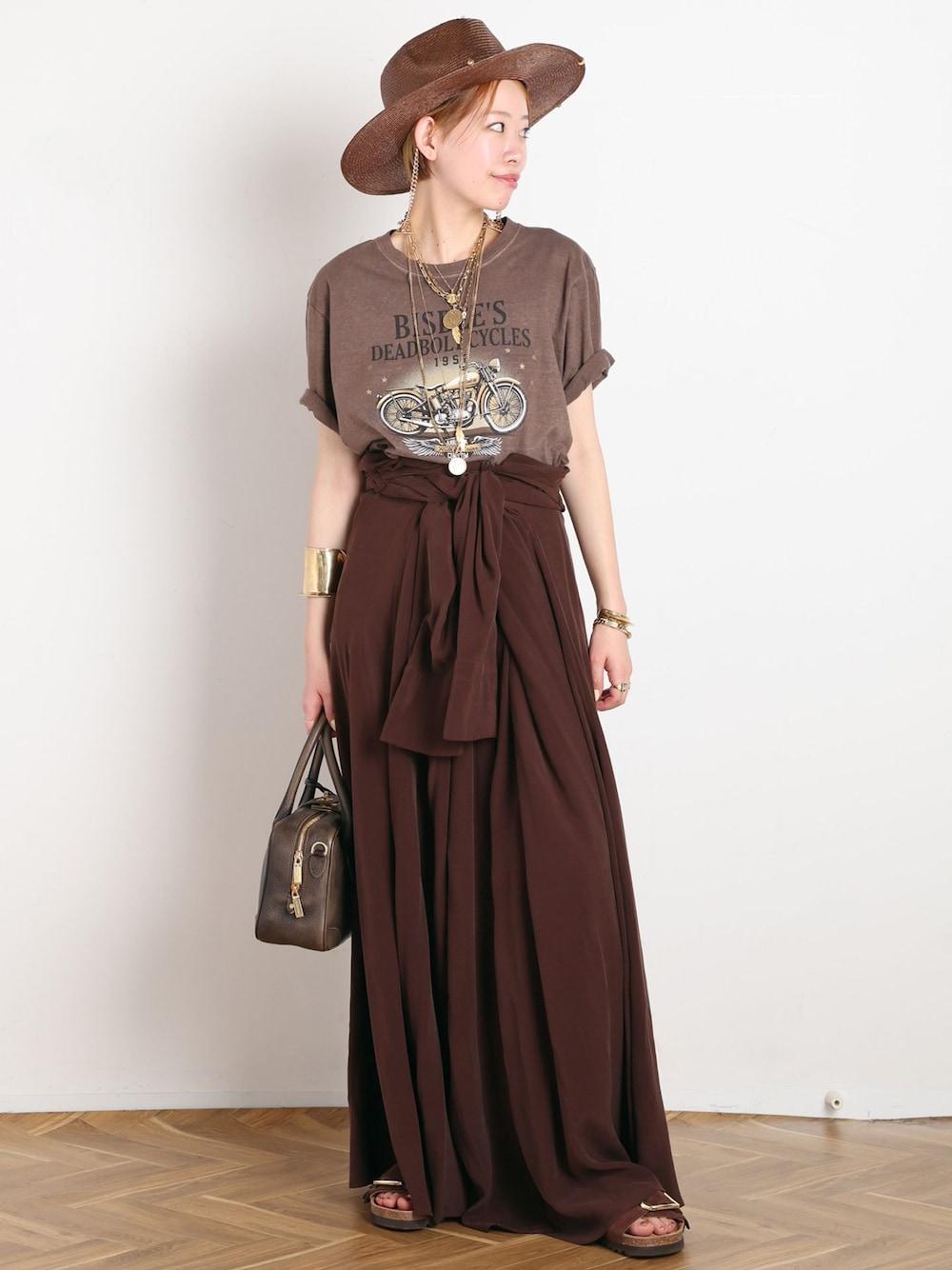ブラウン系のワンピース、ブラウン系のTシャツ/カットソー、ブラウン系のサンダルを着用したレディースの春コーディネートの1枚目の写真