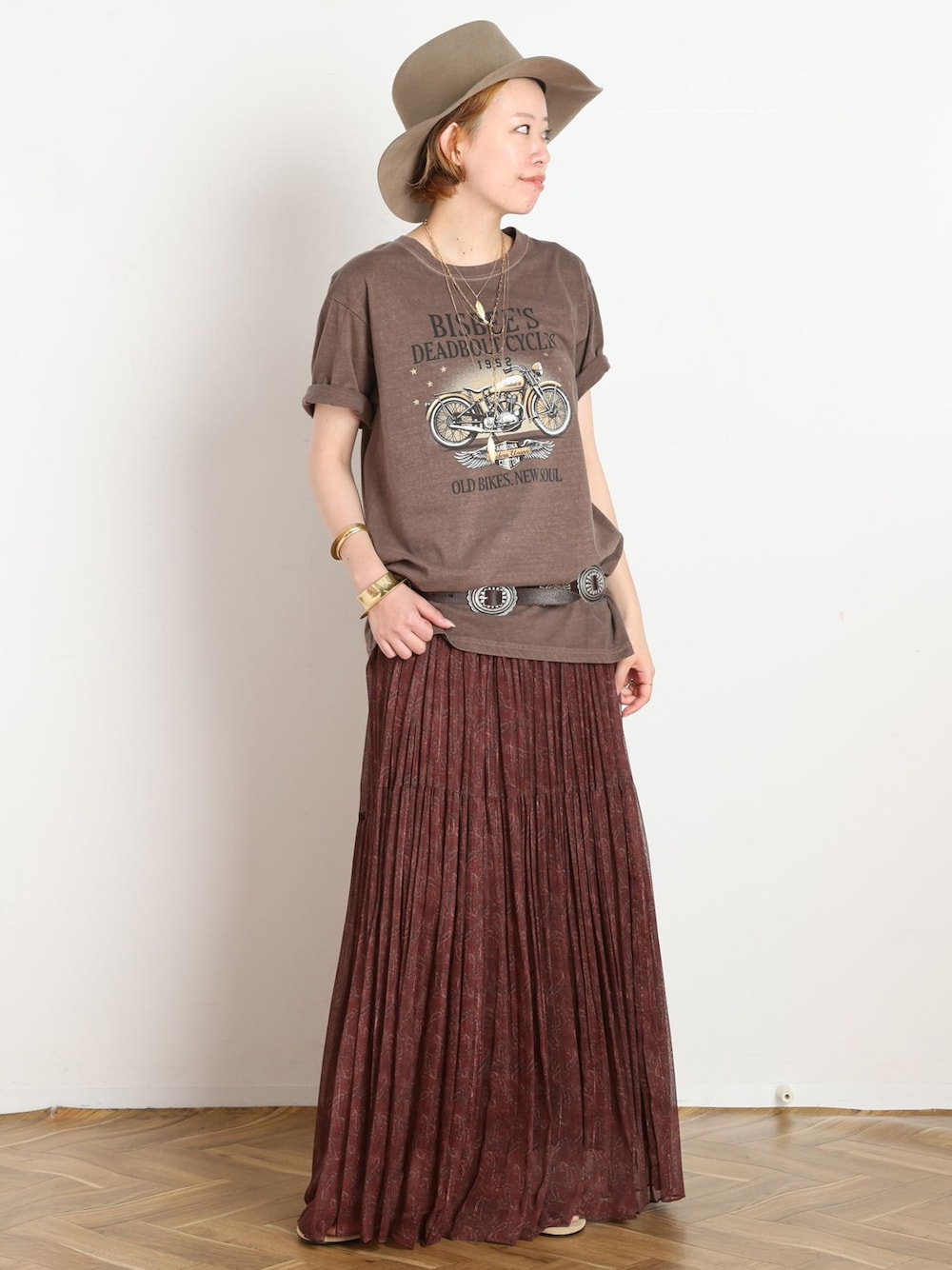 ホワイト系のスカート、ブラウン系のTシャツ/カットソー、ベージュ系のサンダルを着用したレディースの春コーディネートの1枚目の写真