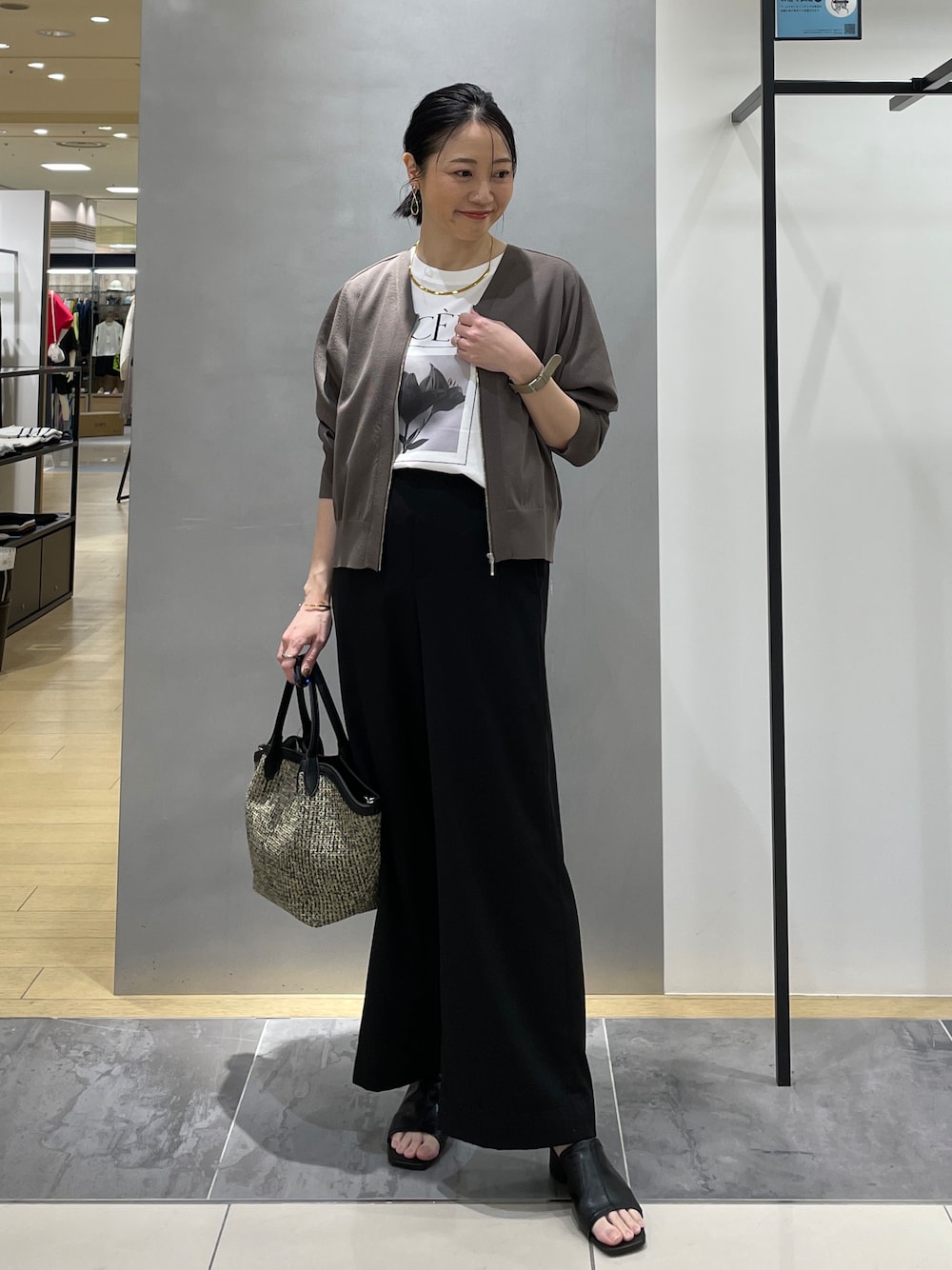 ブラック系のその他パンツ、ブラック系のトートバッグ、ブラウン系のカーディガン/ボレロを着用したレディースの春コーディネートの1枚目の写真