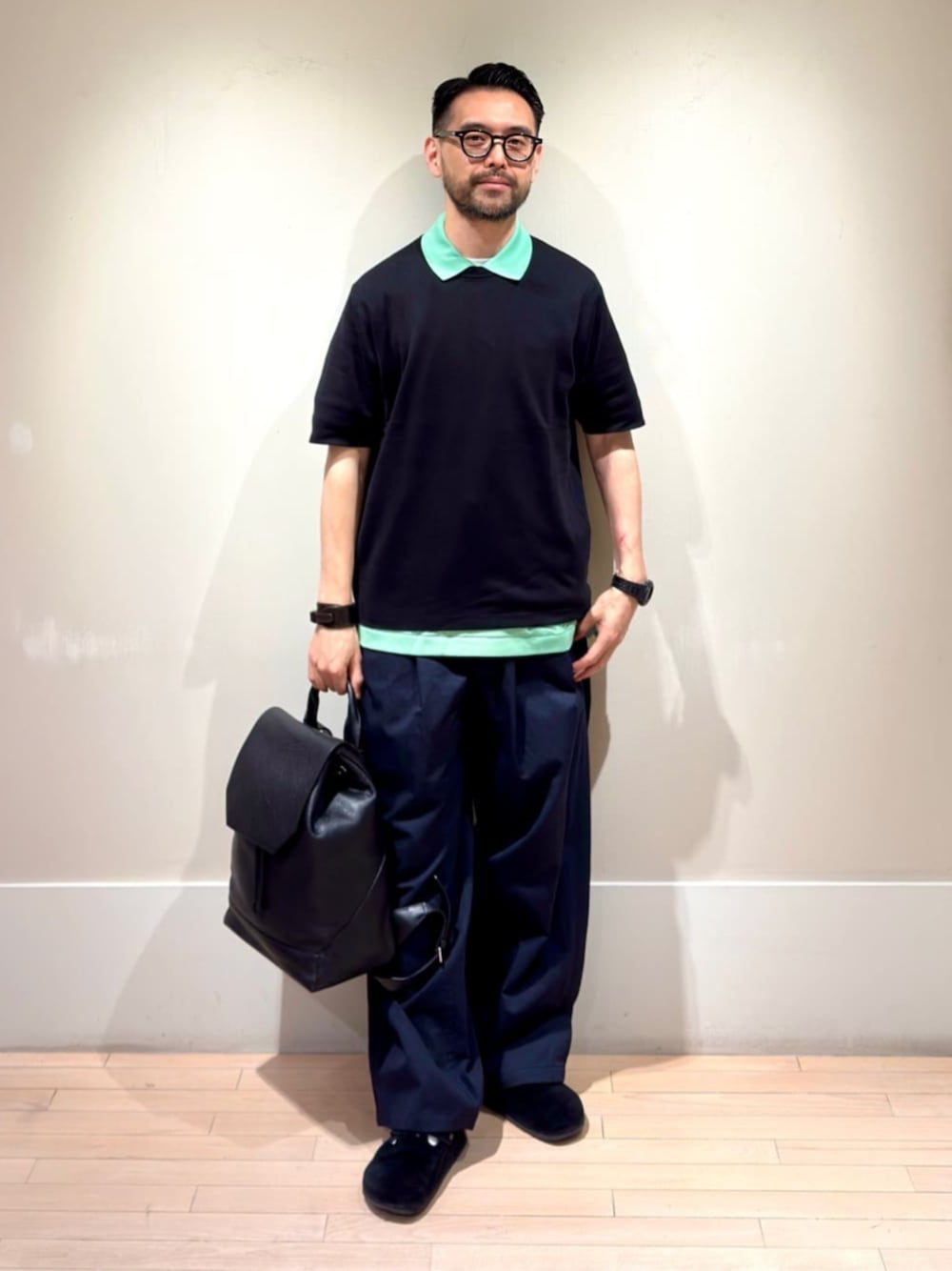 「TOMORROWLAND、トゥモローランド、LACOSTE、TOMORROWLAND tricot、シーアイランドコットン、ポロシャツ、グリーン、レイヤードスタイル、レザーリュック、レザーバックパック、カジュアル」｜「TOMORROWLAND のTOMORROWLAND Tricot シーアイランドコットン ハーフスリーブクルーネックニット（ニット/セーター、ブラック系）」を使った、Mashio_TOMORROWLANDさん（メンズ・175cm）の春コーディネートの1枚目の写真