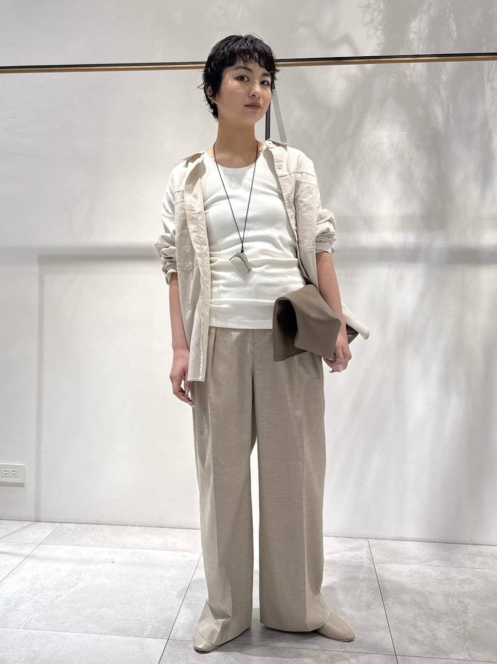 ベージュ系のシャツ/ブラウス、ベージュ系のパンプス、ベージュ系のスラックスを着用したレディースの春コーディネートの1枚目の写真