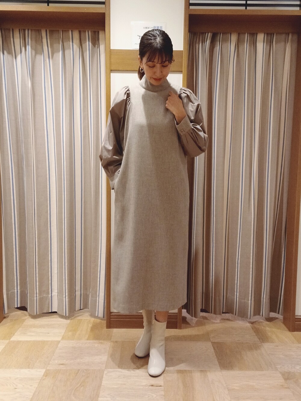 ベージュ系のワンピースを着用したレディースの秋コーディネートの1枚目の写真