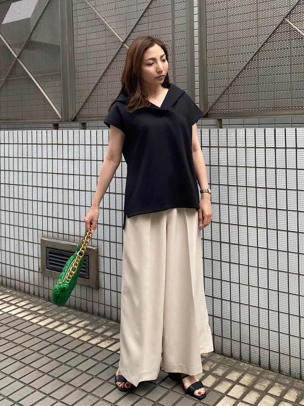 ブラック系のパーカー、ベージュ系のその他パンツを着用したレディースの春コーディネートの1枚目の写真