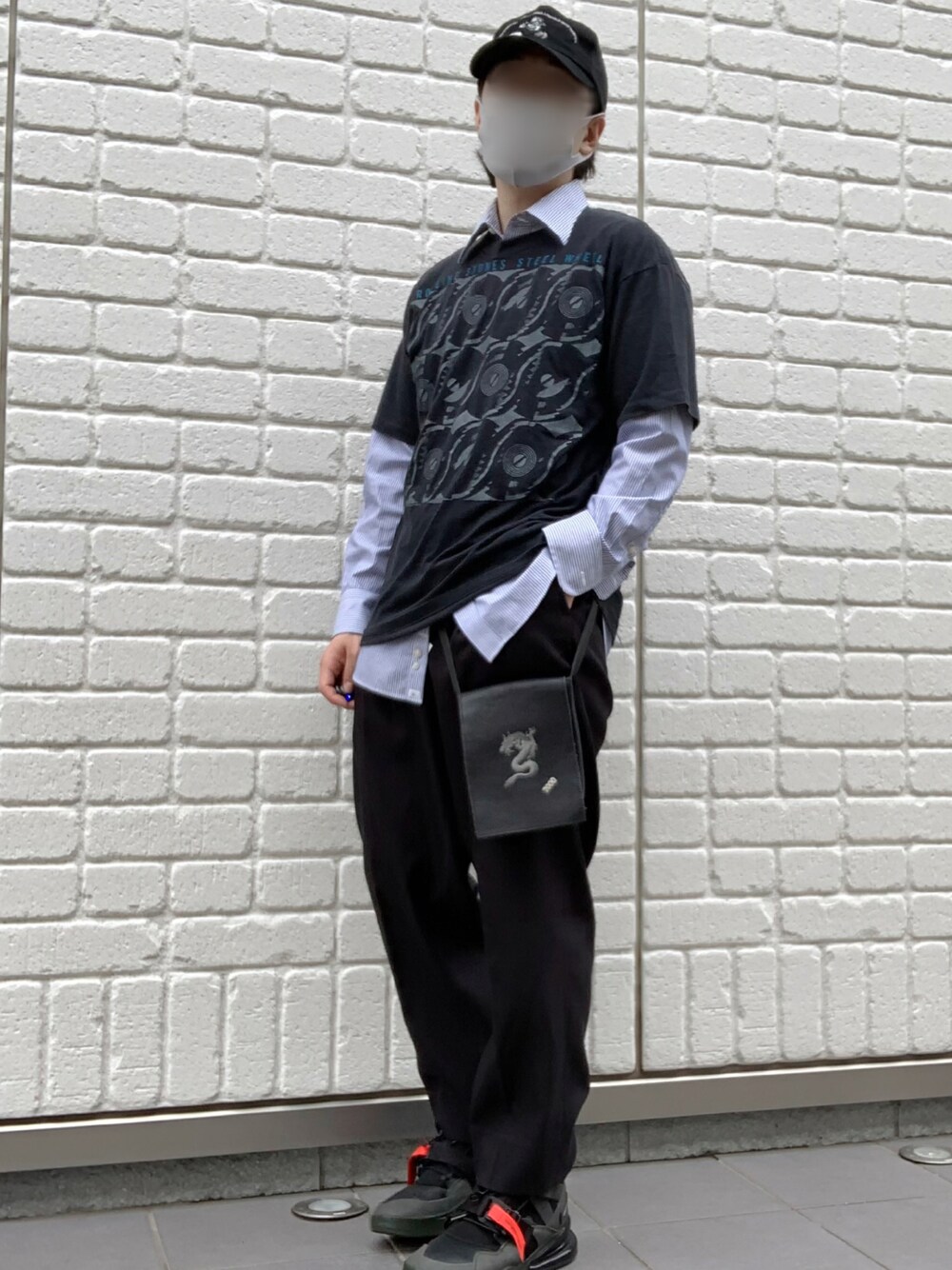 ブルー系のシャツ/ブラウス、グリーン系のトップス、ブラック系のスニーカーを着用したメンズの春コーディネートの1枚目の写真