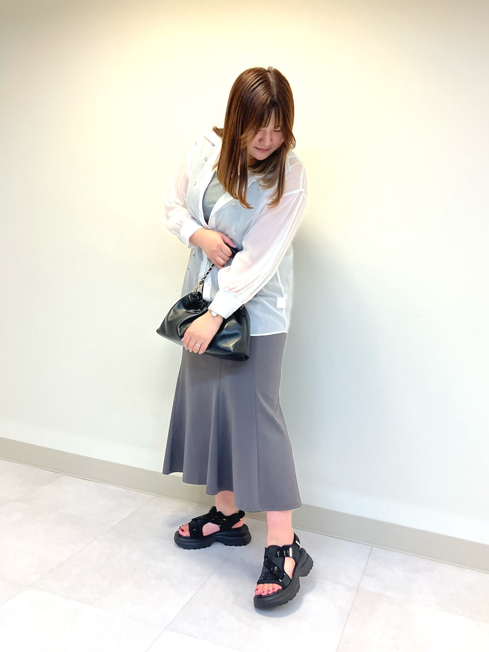 ブラック系のサンダル、ブラック系のショルダーバッグを着用したレディースの春コーディネートの1枚目の写真