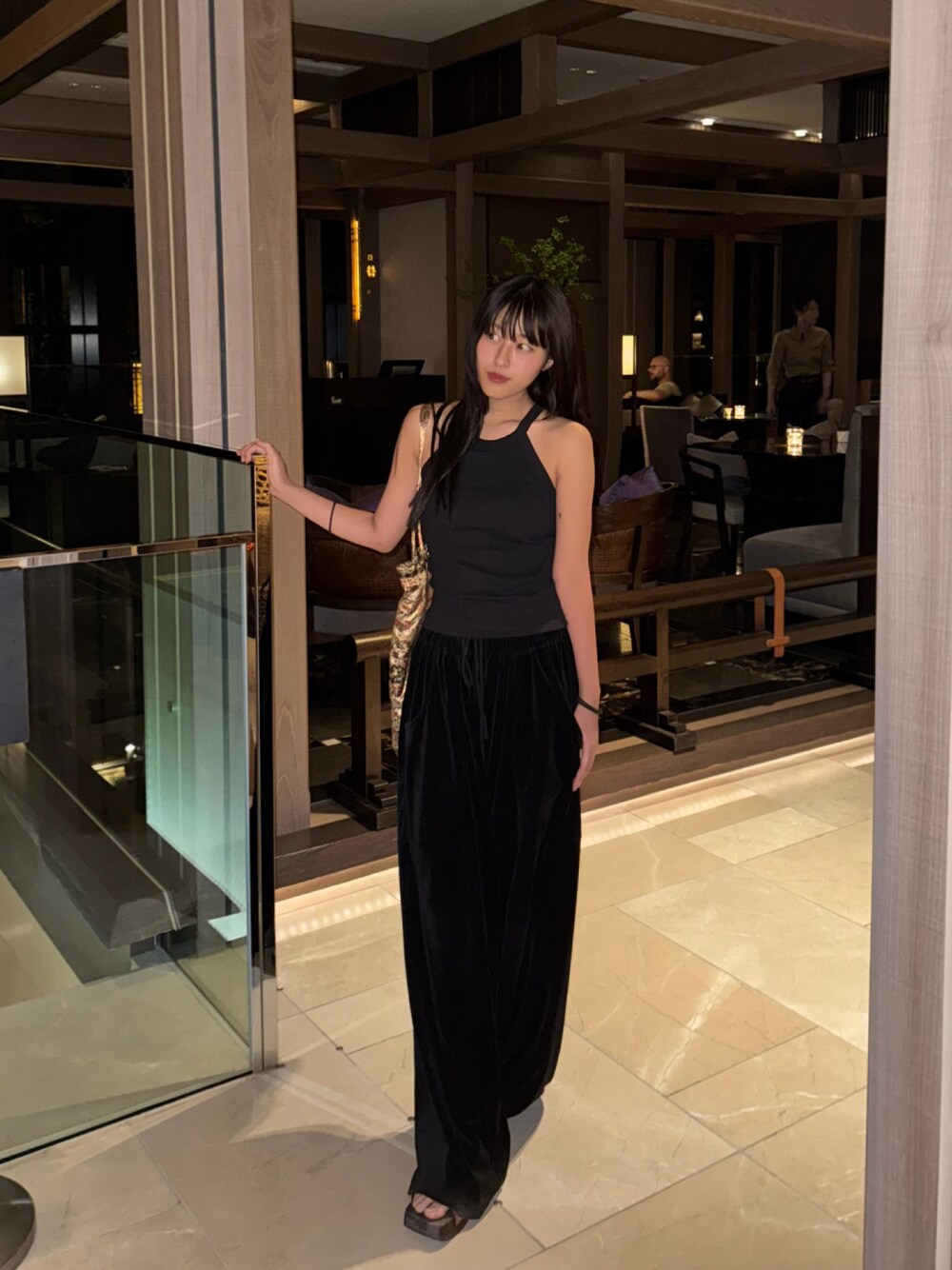 ブラック系のトップスを着用したレディースの夏コーディネートの1枚目の写真