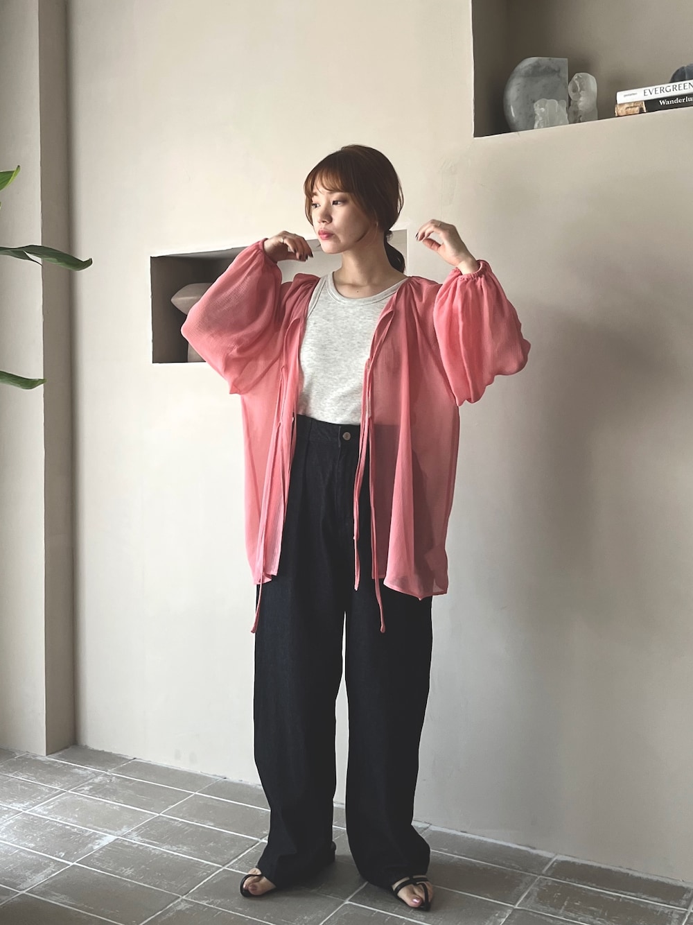 ブラック系のデニムパンツ、ブラック系のサンダル、ベージュ系のタンクトップを着用したレディースの春コーディネートの1枚目の写真