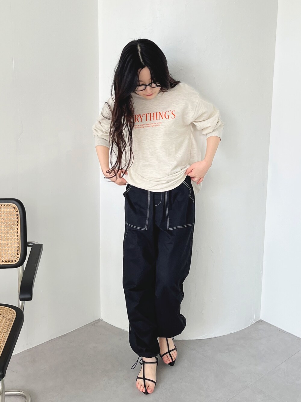 ブラック系のカーゴパンツ、ブラック系のサンダル、ベージュ系のスウェットを着用したレディースの冬コーディネートの1枚目の写真