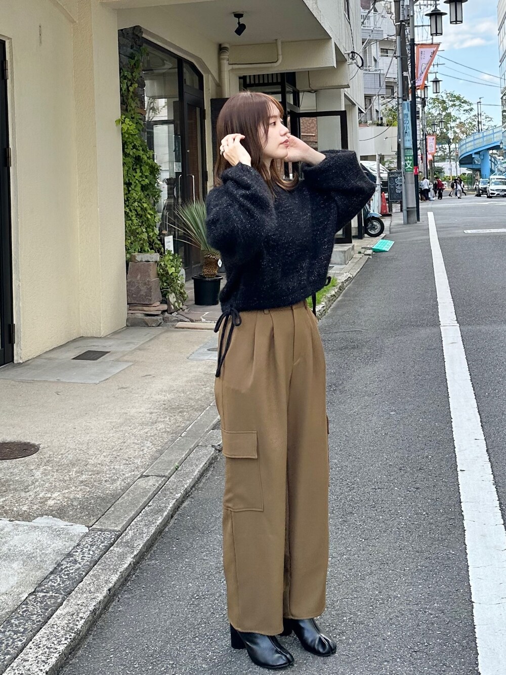 グリーン系のカーゴパンツ、ブラック系のニット/セーター、ブラック系のブーツを着用したレディースの秋コーディネートの1枚目の写真