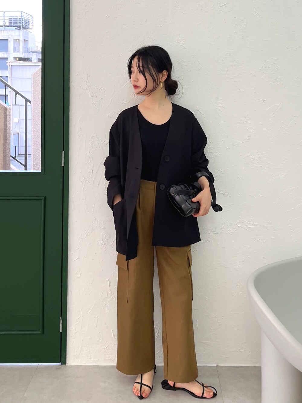 グリーン系のカーゴパンツ、ブラック系のサンダル、ブラック系のノーカラージャケットを着用したレディースの冬コーディネートの1枚目の写真