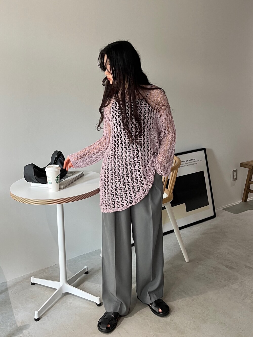 ピンク系のニット/セーター、ブラック系のキャミソール、グレー系のスラックスを着用したレディースの春コーディネートの1枚目の写真