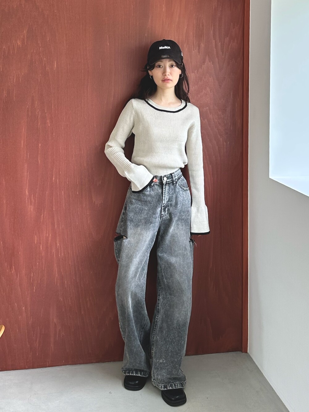 ブラック系のデニムパンツ、ブラック系のスリッポン、ホワイト系のニット/セーターを着用したレディースの秋コーディネートの1枚目の写真