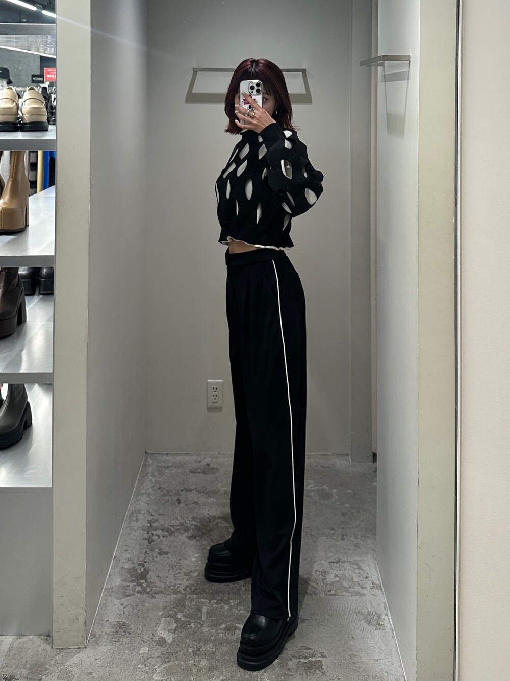 ブラック系のスラックス、ブラック系のニット/セーター、ブラック系のローファーを着用したレディースの冬コーディネートの1枚目の写真