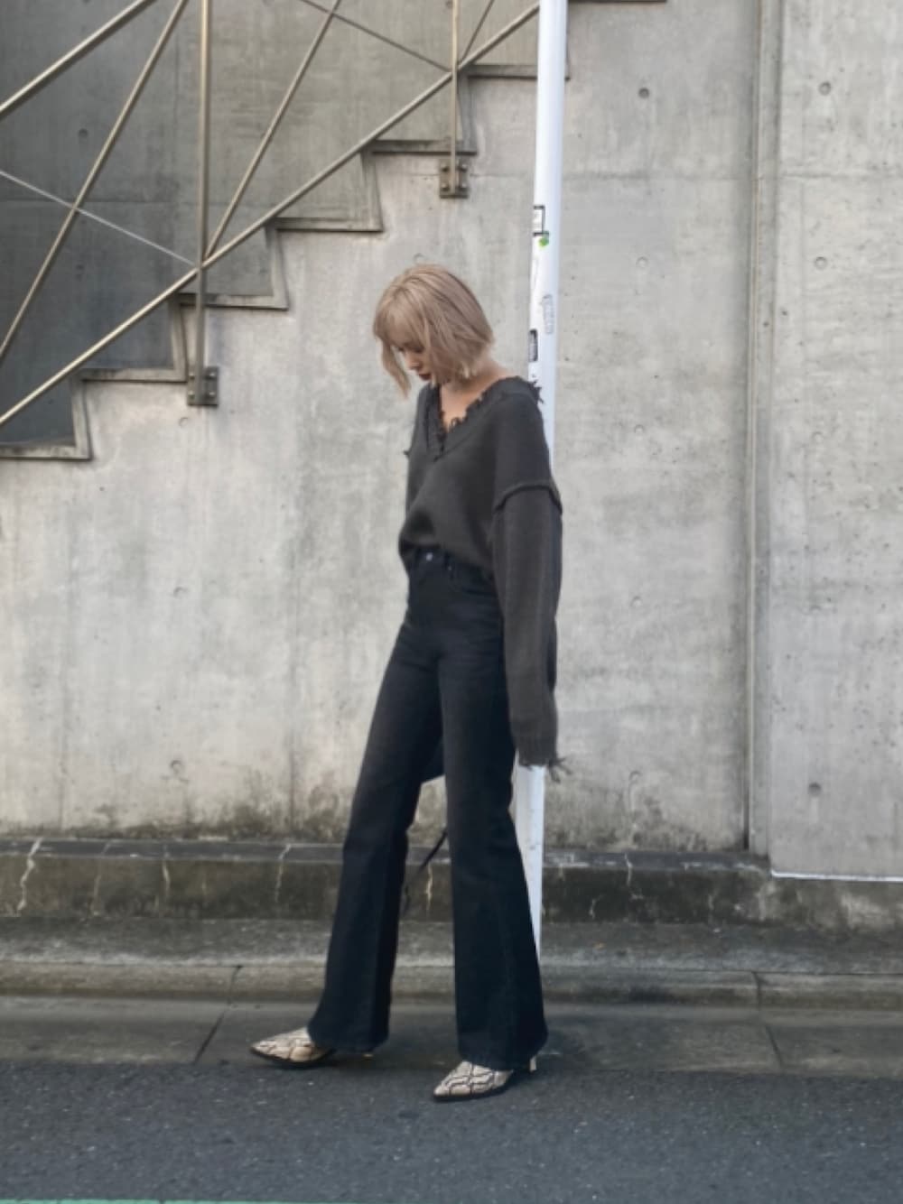 グレー系のニット/セーター、ブラック系のデニムパンツ、その他のパンプスを着用したレディースの秋コーディネートの1枚目の写真