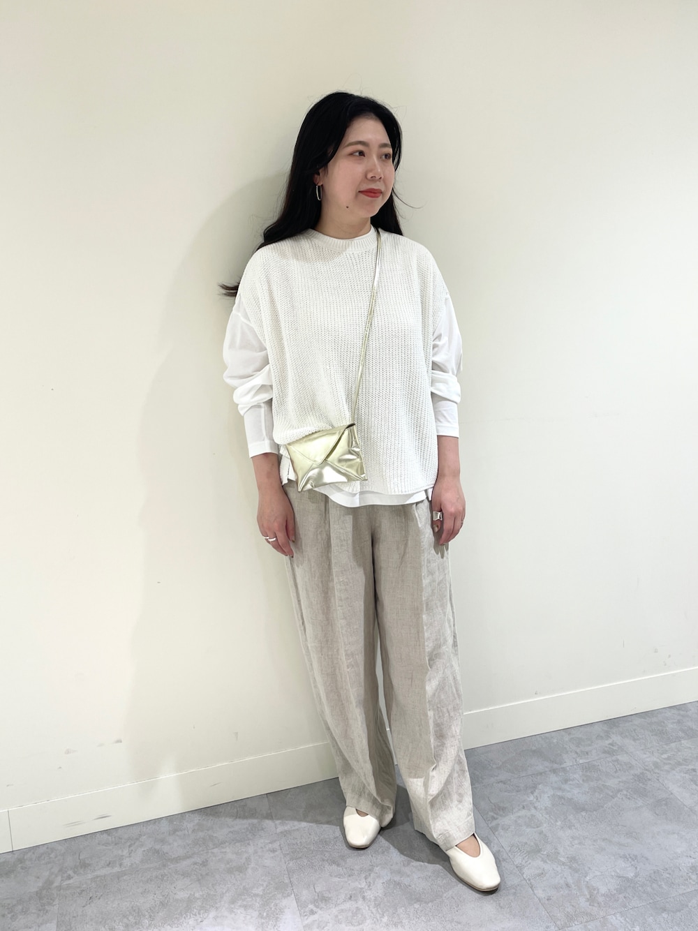 ホワイト系のニット/セーター、ホワイト系のTシャツ/カットソー、ベージュ系のその他パンツを着用したレディースの春コーディネートの1枚目の写真