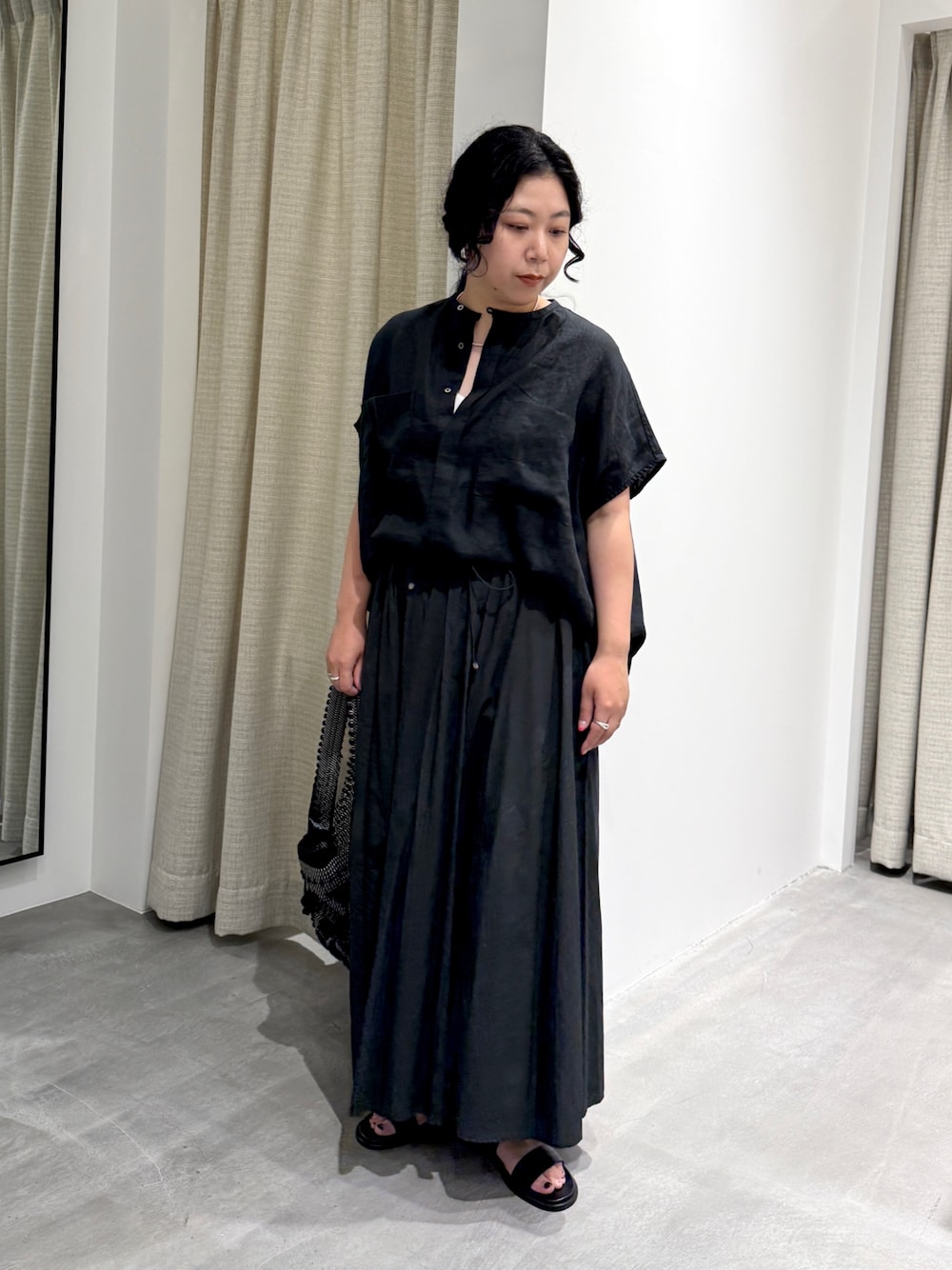 ブラック系のシャツ/ブラウス、ブラック系のスカート、ブラック系のショルダーバッグを着用したレディースの夏コーディネートの1枚目の写真
