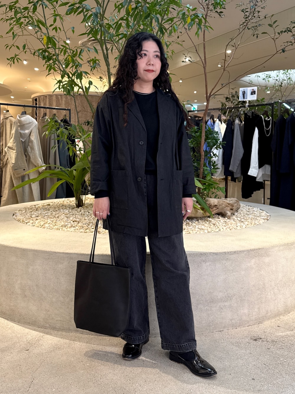 ブラック系のTシャツ/カットソー、ブラック系のデニムパンツ、ブラック系のトートバッグを着用したレディースの冬コーディネートの1枚目の写真