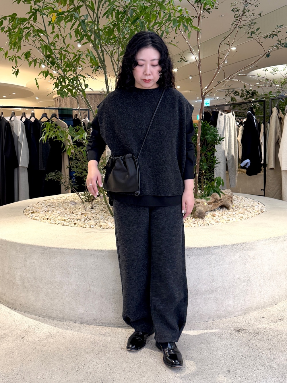 ブラック系のショルダーバッグ、ブラック系のシャツ/ブラウス、グレー系のその他パンツを着用したレディースの冬コーディネートの1枚目の写真