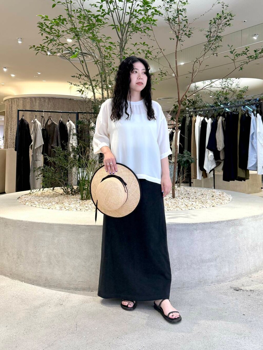 ブラック系のスカート、ホワイト系のTシャツ/カットソーを着用したレディースの夏コーディネートの1枚目の写真