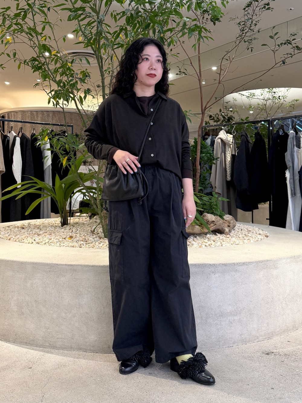 ブラック系のショルダーバッグ、ブラウン系のTシャツ/カットソー、ブラウン系のシャツ/ブラウスを着用したレディースの冬コーディネートの1枚目の写真