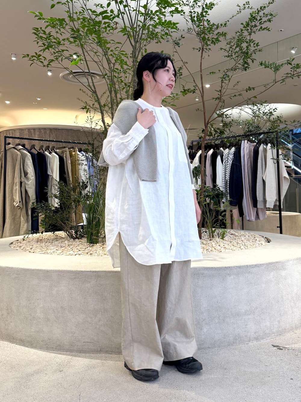 グレー系のニット/セーター、ホワイト系のシャツ/ブラウス、ベージュ系のその他パンツを着用したレディースの春コーディネートの1枚目の写真