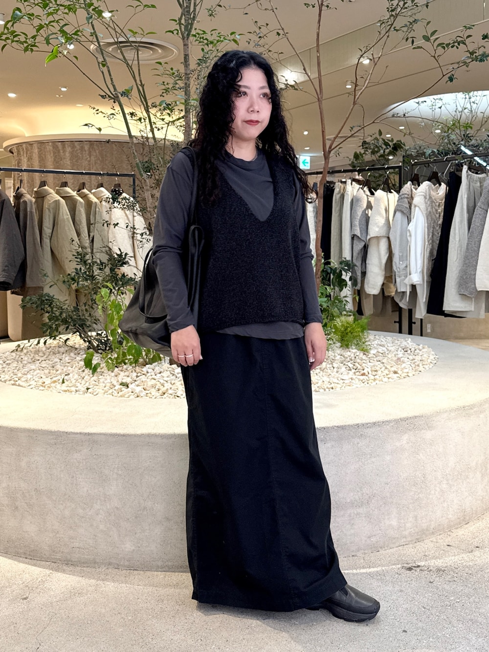 グレー系のTシャツ/カットソー、ブラック系のスカート、ブラック系のトートバッグを着用したレディースの秋コーディネートの1枚目の写真