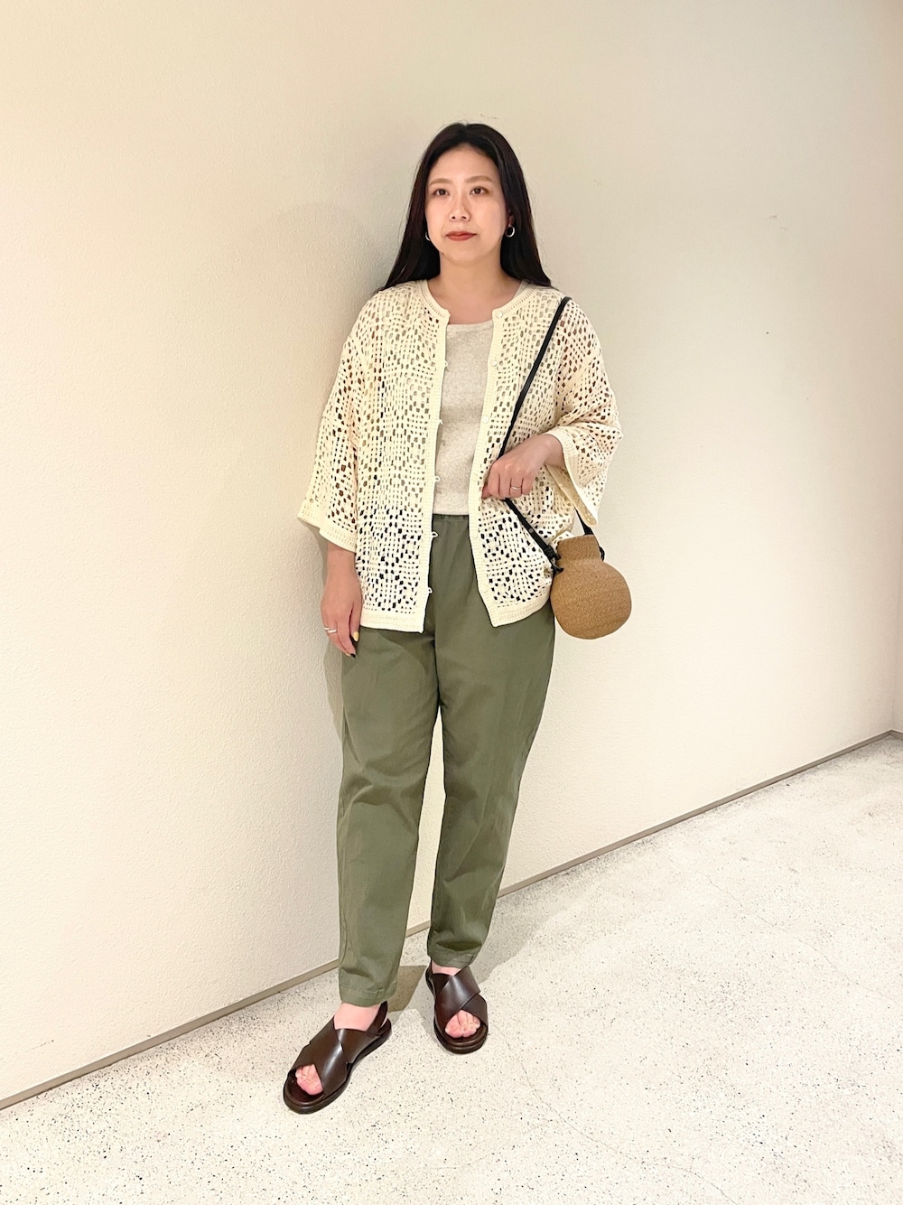 ホワイト系のニット/セーター、グリーン系のその他パンツ、ベージュ系のかごバッグを着用したレディースの夏コーディネートの1枚目の写真